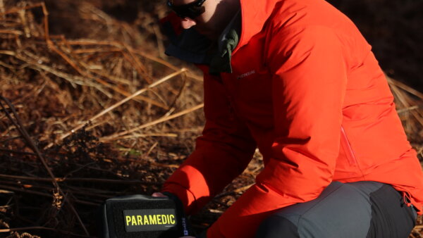 a man holding the paramedic bag in the forest