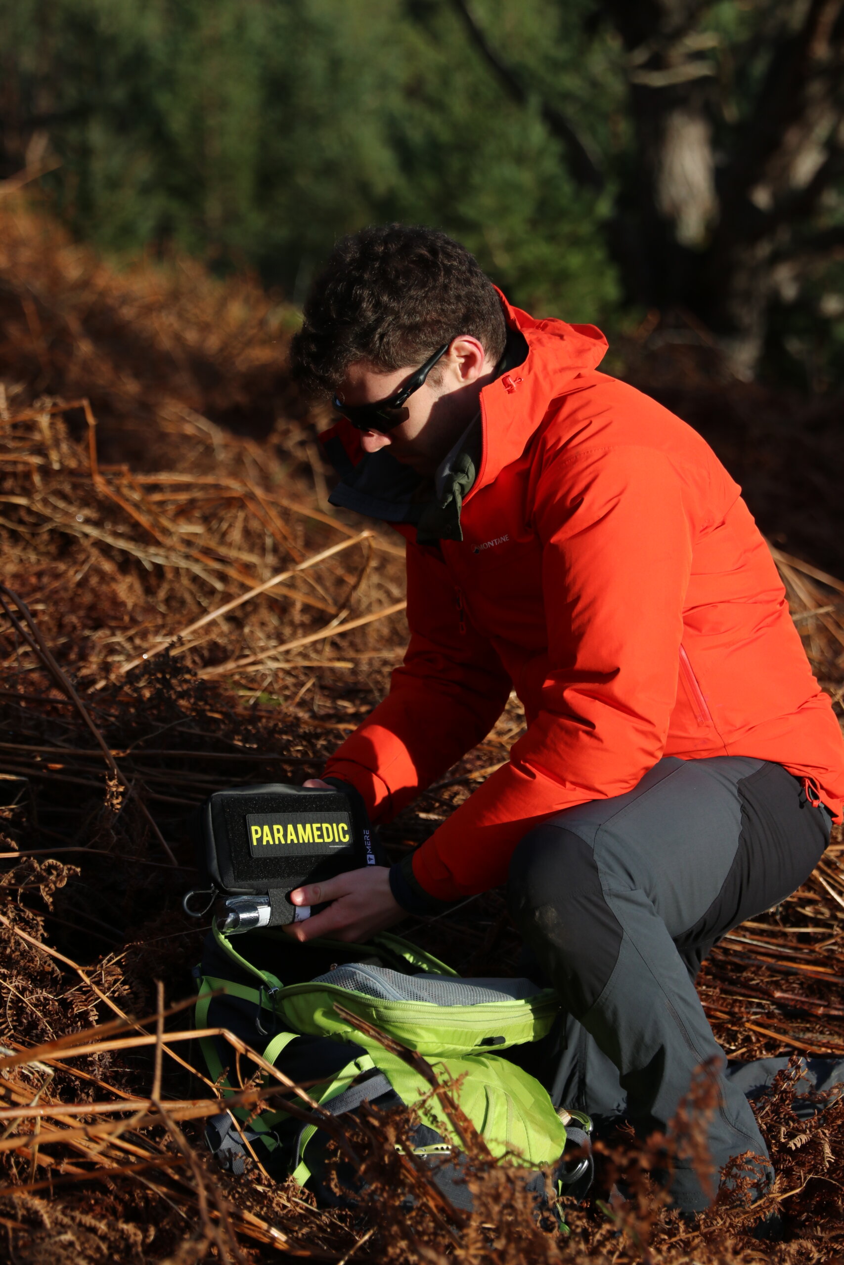 a man holding the paramedic bag in the forest